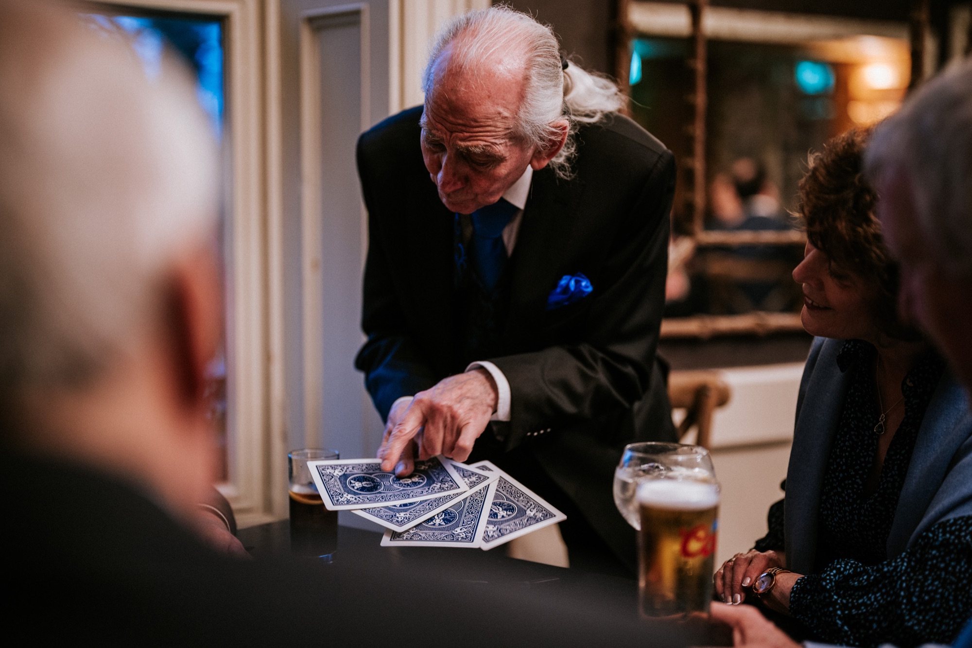 Pat Fallon performing close-up card magic for seated guests